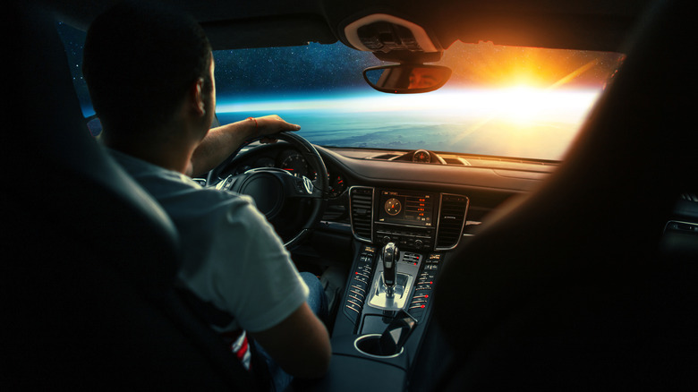 A man driving a car through space
