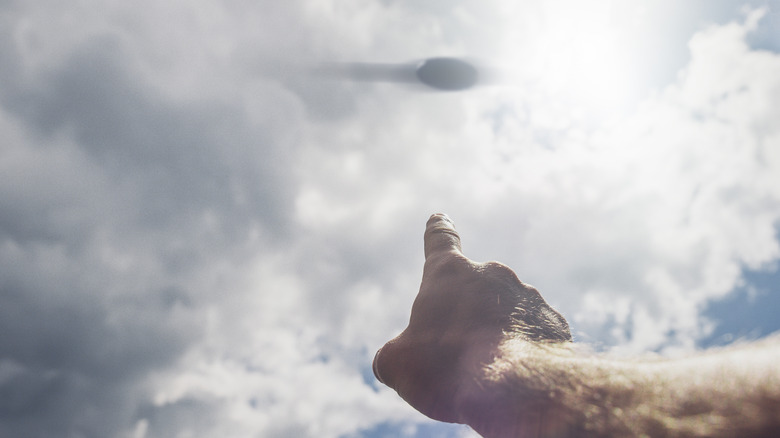 Someone pointing at a UFO in the clouds