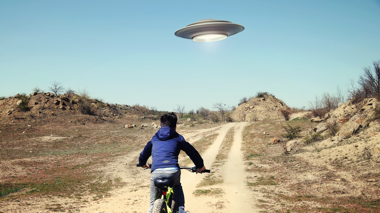 Kid biking toward UFO