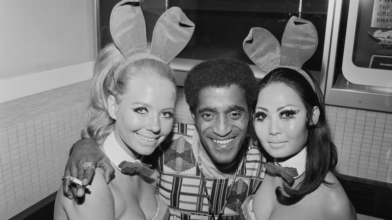 Sammy David Jr. smiling between two Playboy bunnies