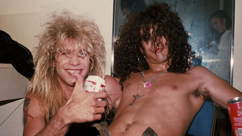 Steven Adler and Slash, both with beer cans and grinning