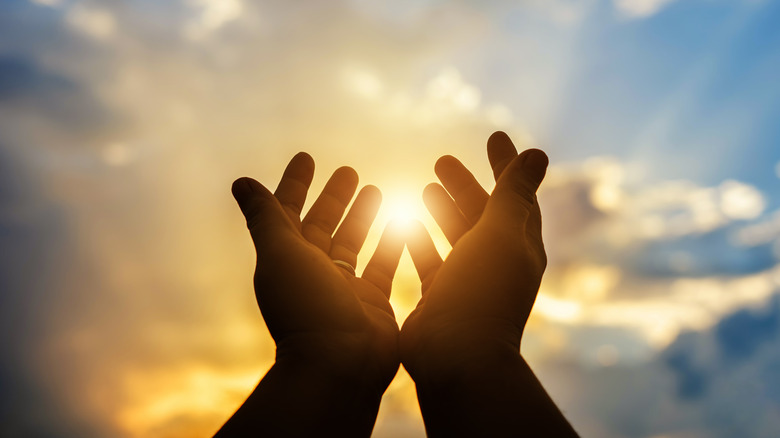 silhouette of hands on sky