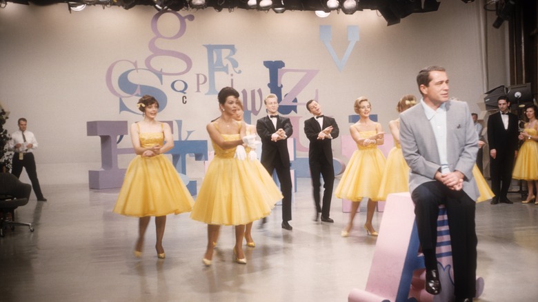 Perry Como seated and singing in front of dancing women
