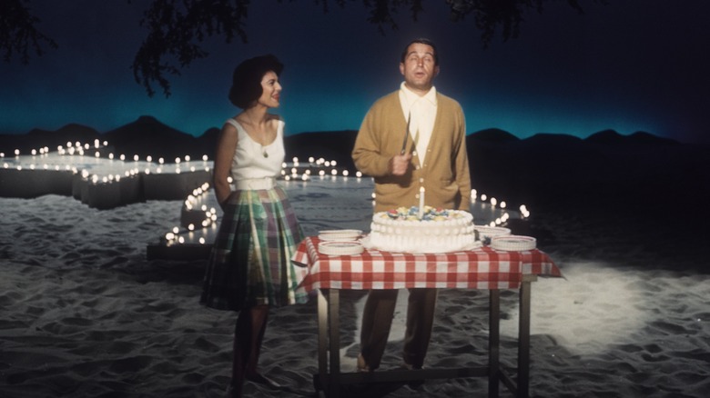 Ann Bancroft and Perry Como in front of table with cake