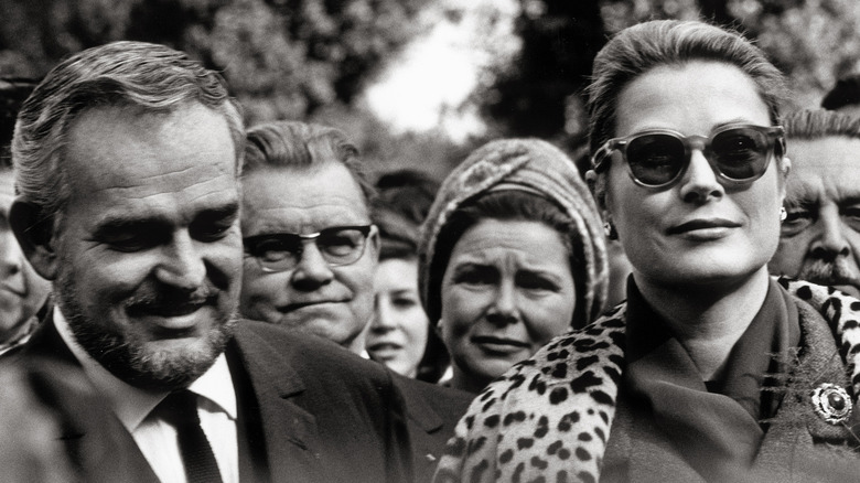 Prince Rainier III and Grace Kelly walking outside, smiling