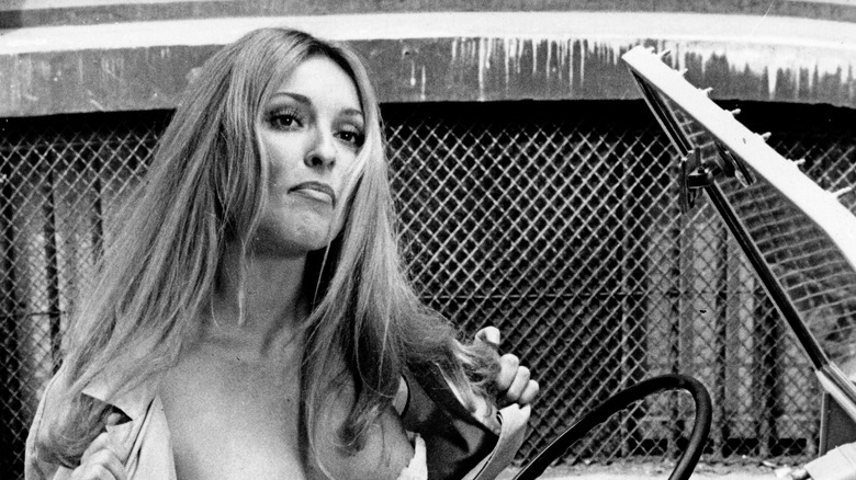 Sharon Tate holding jacket open in 