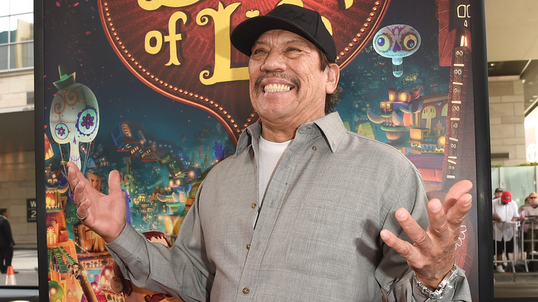 Danny Trejo, smiling, hands in air