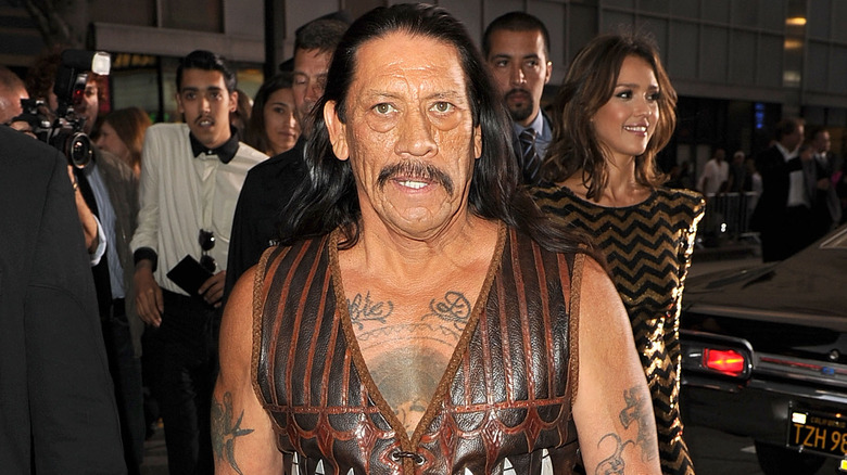 Danny Trejo walking in a vest