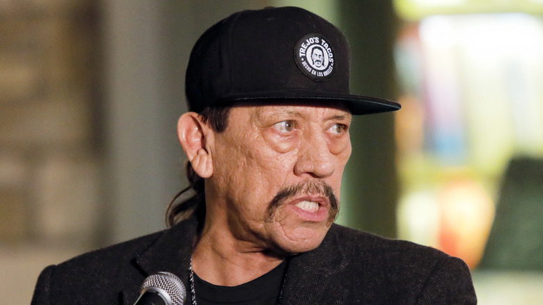 Danny Trejo speaking into microphone