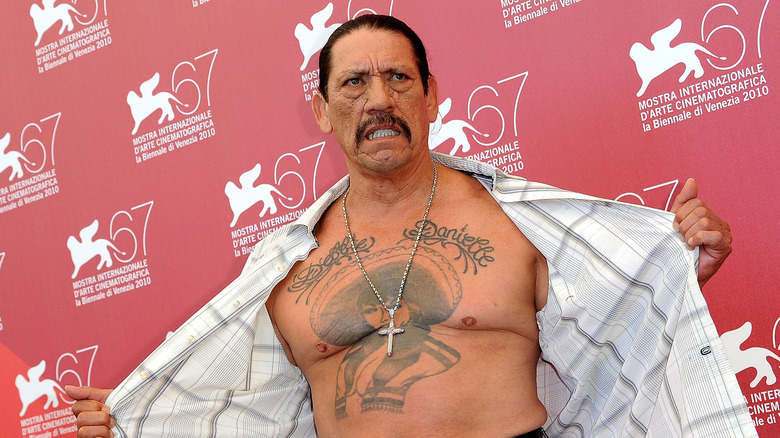 Danny Trejo showing off chest tattoo