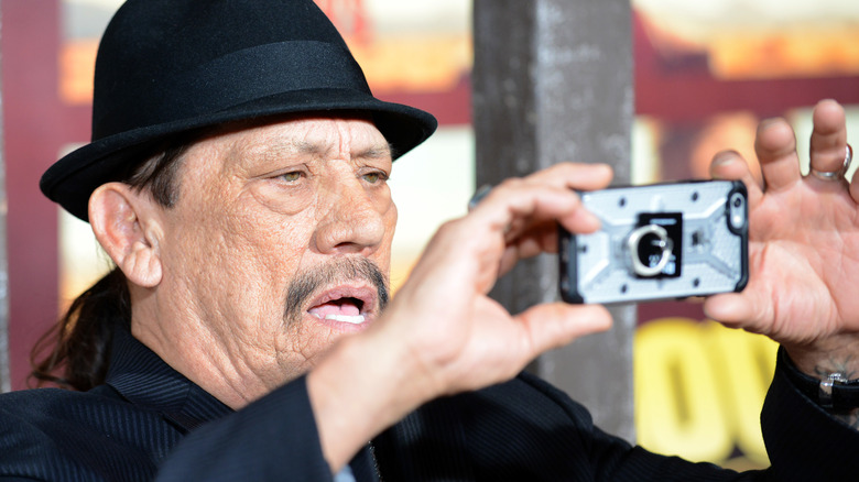 Danny Trejo taking picture on phone