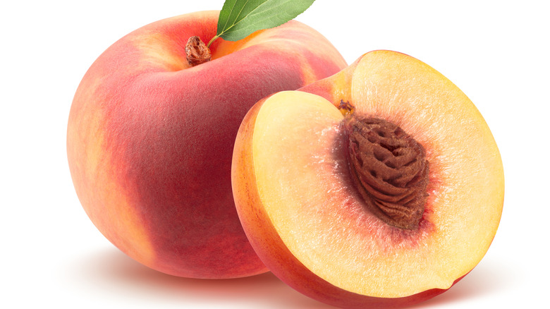 Two peaches, one sliced 