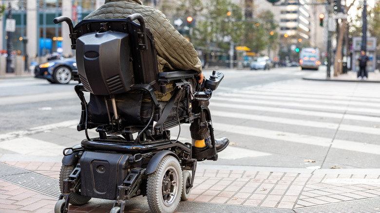Man in wheelchair crossing street