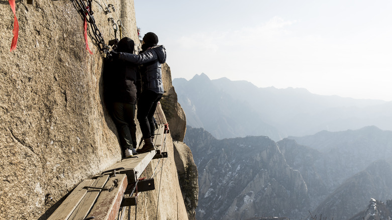 hikers on mount huashan cliff walk