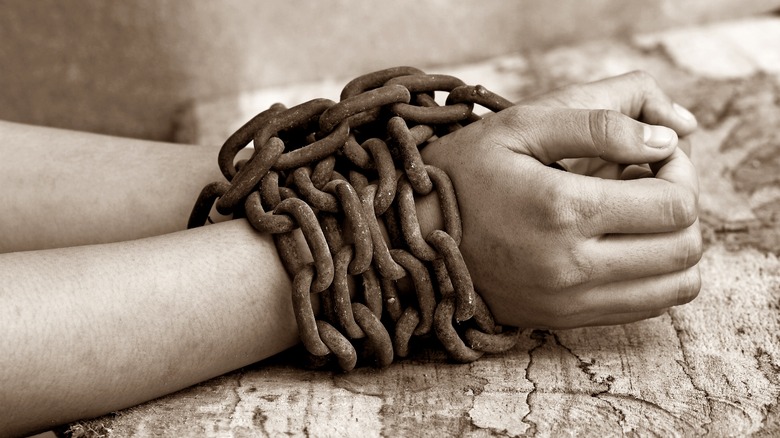 A woman's hand bound in chains