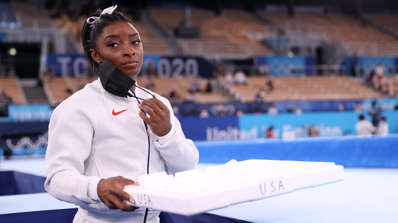 Simone Biles holding a tray of chalk