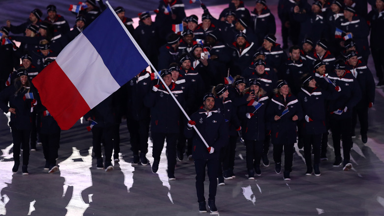 Crowd of athletes behind French flag