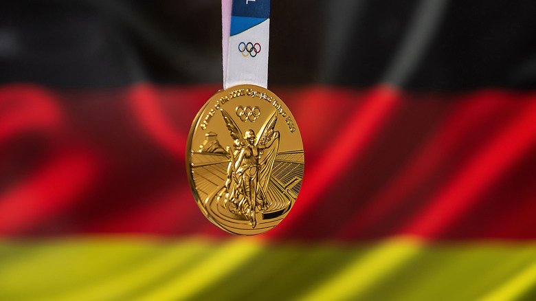 Gold medal hangs in front of German flag