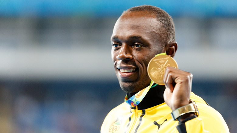 Usain Bolt holding gold medal
