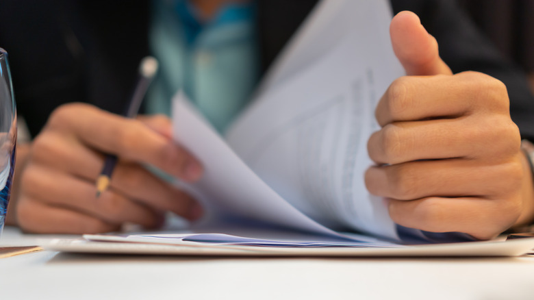 hands leafing through paperwork