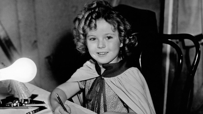 Shirley Temple seated and smiling