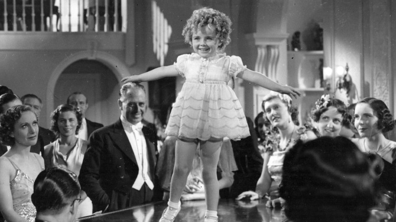 Shirley Temple on top of a piano
