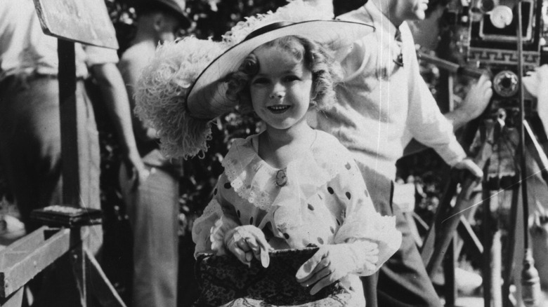 Shirley Temple seated and smiling