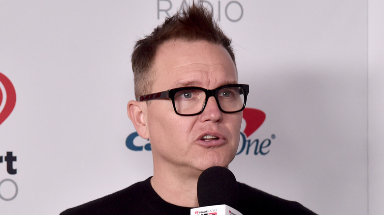 Mark Hoppus glasses speaking into mic