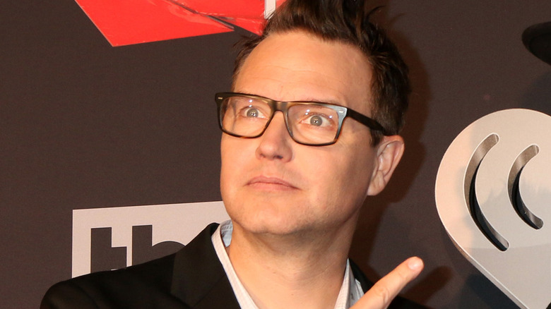 Mark Hoppus wearing glasses and pointing