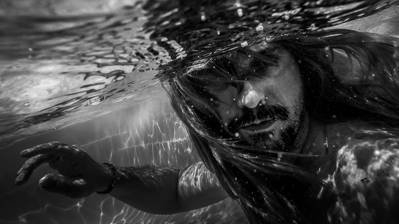 Merman with hair flowing in water