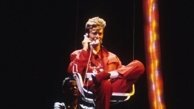 David Bowie singing into a telephone