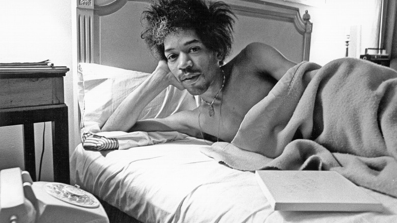 Jimi Hendrix in bed near a phone