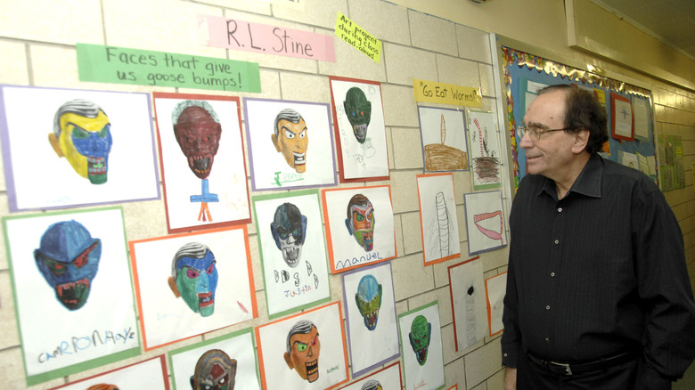R.L. Stine looking at children's drawings
