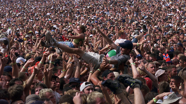 Man and woman crowd surfing