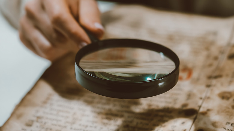 Magnifying glass over ancient text