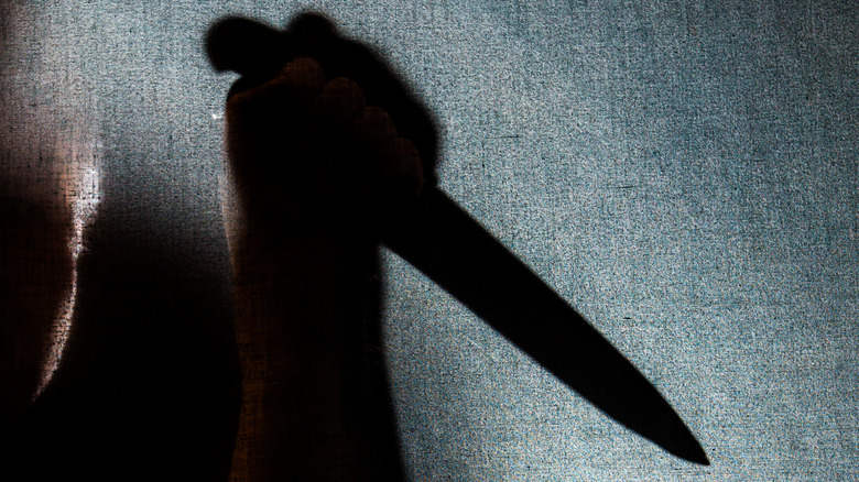Shadow of hand with knife