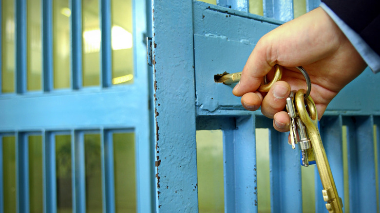 Person unlocking prison cell door