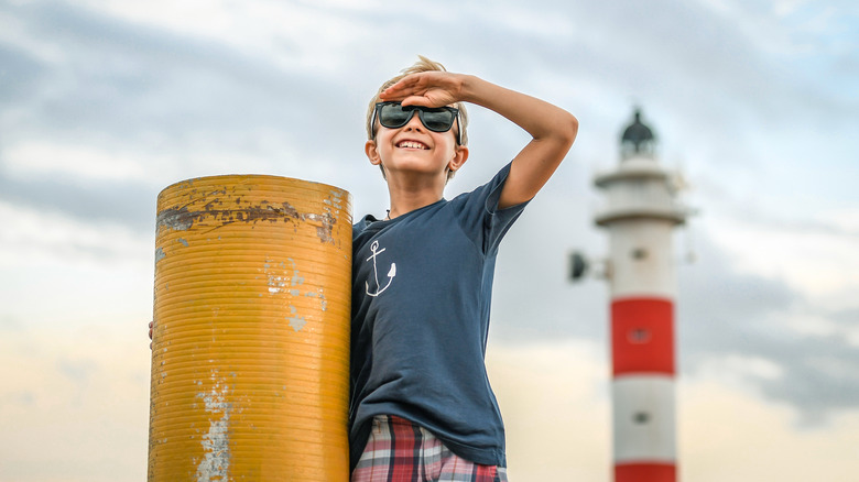 Boy in front of lighthouse