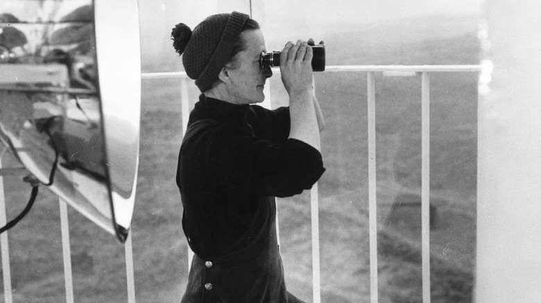 Lighthouse keeper using binoculars