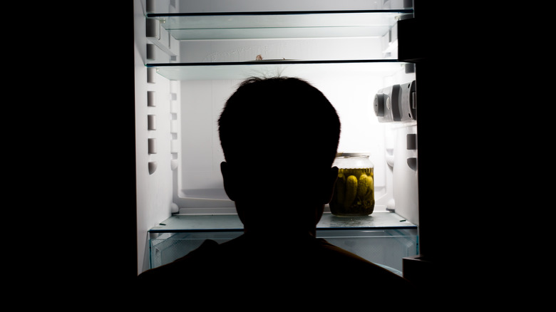 Man in front of almost empty fridge