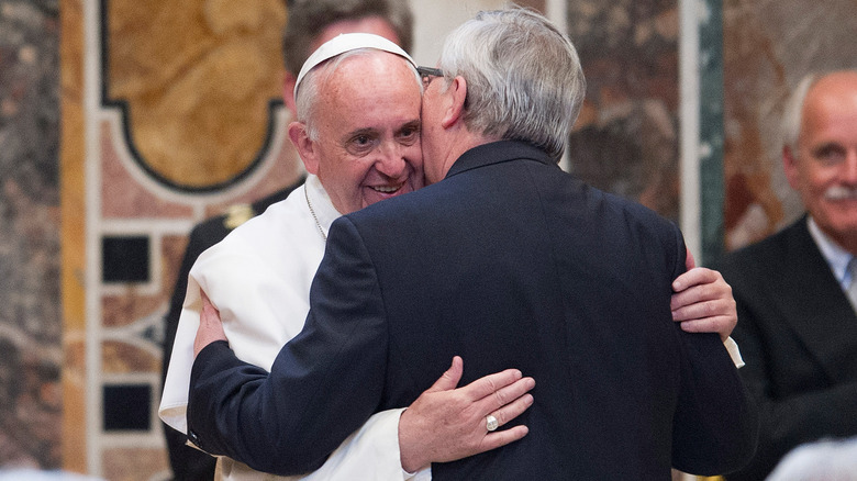 Jon Claude Junker hugging Pope Francis