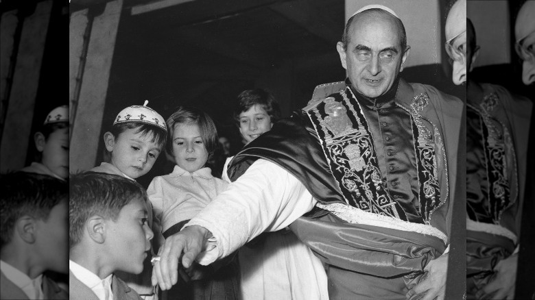A child kissing the pope's ring