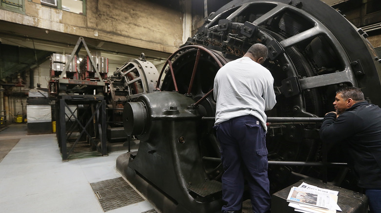 Two men work on a rotary converter in the basement of Grand Central.