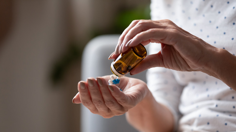 Woman emptying pill bottle