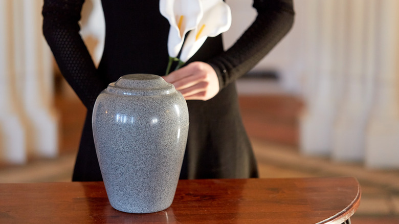 a mourner and a cremation urn