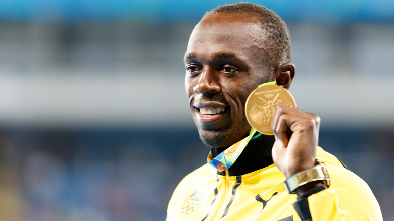 Usain Bolt holding gold medal