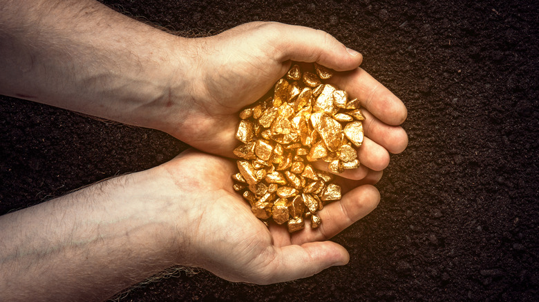 man holding gold nuggets