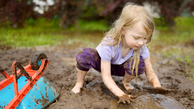 child playing in the mud