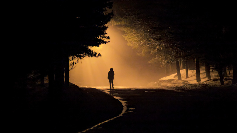 Person walking down dark road