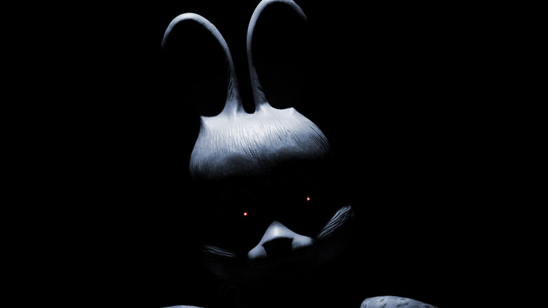 Person in bunny costume stares from darkness
